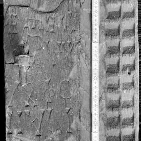 Fragment din portalul original, montantul drept, semnătura meșterului, care se poate citi fie Gozdă fie Gogiă. De remarcat că jumătatea din stânga a montantului lipsește. Foto și decalcare 1999.