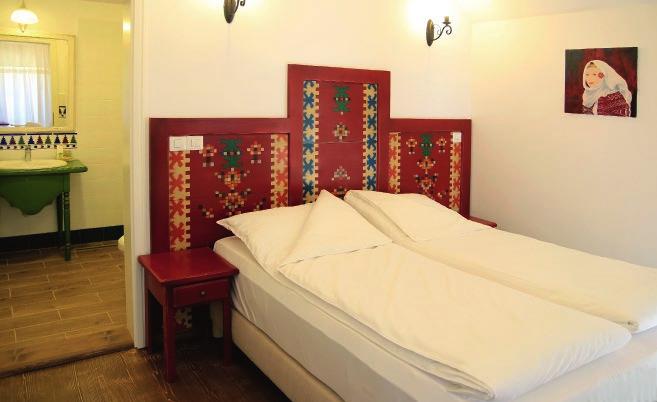 Câteva motive geometrice, inspirate din tradiția poporului român, decorează tăblia de lemn a patului din Camera Vișinie.